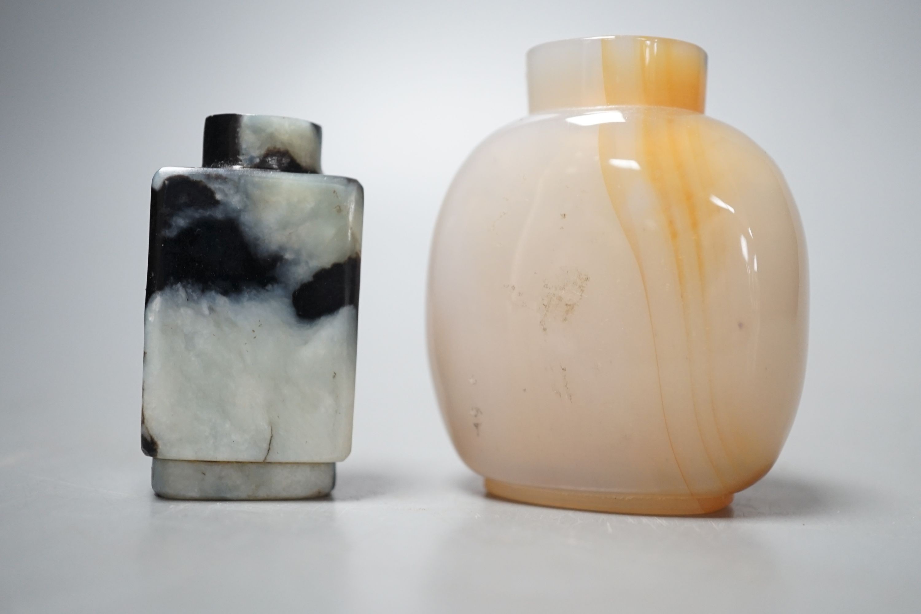 A Chinese white and black jade snuff bottle and a similar agate snuff bottle